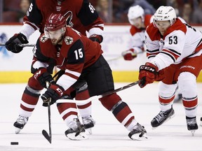 Arizona Coyotes center Brad Richardson (15) skates with the puck in front of Carolina Hurricanes left wing Jeff Skinner (53) during the first period of an NHL hockey game Saturday, Nov. 4, 2017, in Glendale, Ariz. (AP Photo/Ross D. Franklin)