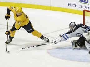 Nick Bonino of the Nashville Predators protects the puck as he prepares to backhand it past Winnipeg Jets' goaltender Connor Hellebuyck during NHL action Monday night in Nashville. Bonino had a goal as the Predators posted a 5-3 victory.