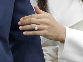 Britain's Prince Harry's fiancee Meghan Markle shows off her engagement ring as she poses for photographers during a photocall in the grounds of Kensington Palace in London, Monday Nov. 27, 2017.