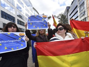 Anti Catalonia independence demonstrators hold Spanish flags and posters during a protest coinciding with the arrival of the Catalan mayors who travelled to Brussels to take part in an event in support of the ousted Catalan government on Tuesday, Nov. 7, 2017. Puigdemont is fighting extradition to Spain, where other members of the ousted Cabinet have been sent to jail while awaiting the results of a probe for allegedly weaving a strategy to secede from Spain. (AP Photo/Geert Vanden Wijngaert)