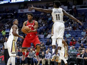 Toronto Raptors guard Kyle Lowry looks to pass against the Pelicans' Dante Cunningham and guard Jrue Holiday in the first half of their game in New Orleans on Wednesday night,