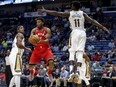 Toronto Raptors guard Kyle Lowry looks to pass against the Pelicans' Dante Cunningham and guard Jrue Holiday in the first half of their game in New Orleans on Wednesday night,