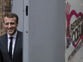 French President Emmanuel Macron visits a branch of French charitable organization 'Les Restos du Coeur' (Restaurants of the Heart) in Paris, France, Tuesday, Nov. 21, 2017. The Restos du Coeur are launching their winter campaign for food distribution to those in need, with demand rising every year. (Ian Langsdon/Pool Photo via AP)