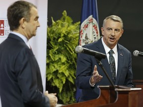FILE - In this Monday Oct. 9, 2016, file photo, Republican gubernatorial candidate, Ed Gillespie, right, gestures during a debate with Democratic challenger Lt. Gov. Ralph Northam, during a debate at University of Virginia-Wise in Wise, Va. Political observers say Virginia's closely watched race for governor has become one of the state's most racially charged campaigns in recent memory. (AP Photo/Steve Helber, File)