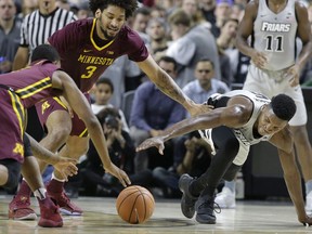 Minnesota's Dupree McBrayer, left, and Jordan Murphy (3) vie with Providence's Rodney Bullock, right, for the ball in the first half of an NCAA college basketball game Monday, Nov. 13, 2017, in Providence, R.I. (AP Photo/Steven Senne)