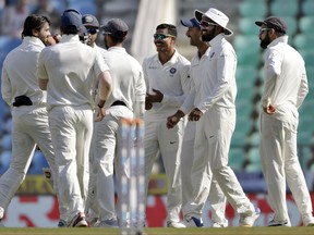 India's Ravindra Jadeja, center without cap, celebrates with teammates the dismissal of Sri Lanka's Dimuth Karunaratne during the fourth day of their second test cricket match in Nagpur, India, Monday, Nov. 27, 2017. (AP Photo/Rajanish Kakade)