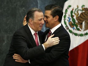 Mexican President Enrique Pena Nieto, right, embraces outgoing Treasury Secretary Jose Antonio Meade at a press conference to announce changes to the president's cabinet at Los Pinos presidential residence in Mexico City, Monday, Nov. 27, 2017. Mexico's president has accepted the resignation of Treasury Secretary Meade, a move that opens up a path for Meade to become the presidential candidate for the ruling Institutional Revolutionary Party in July 1 elections. (AP Photo/Rebecca Blackwell)