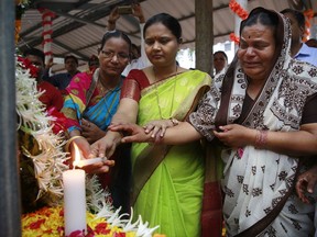 Shushila Ughade, right, who lost her husband in Mumbai terror attacks, light the candle along with others at the memorial on the ninth anniversary in Mumbai, India, Sunday, Nov. 26, 2017. The attack by Pakistani gunmen in India's financial capital on Nov. 26, 2008 killed 166 people and shattered relations between the nuclear-armed neighbors. (AP Photo/Rafiq Maqbool)