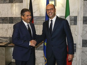 Italian Foreign Minister Angelino Alfano, right, shakes hands with his German counterpart Sigmar Gabriel during their meeting at the Farnesina Palace Foreign Ministry in Rome, Wednesday, Nov. 15, 2017. Italy and Germany defended Wednesday their support for Libyan coast guard patrols returning migrants back to Libya, after the U.N. human rights chief denounced the policy as inhuman. (Fabio Frustaci/ANSA via AP)