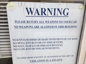 A sign at the entrance to the meeting hall of the Crook County commissioners asks attendees to leave their weapons in their car before a public meeting Wednesday, Nov. 8, 2017 in Prineville, Ore. Crook County Commissioners unanimously adopted a land-use plan that says the county will participate fully in planning and decisions on federal lands that comprise about half of the county in central Oregon. (AP Photo/Andrew Selsky)