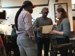 In this Nov. 15, 2017 photo celebrity chef Marcus Samuelsson, center, goes over the final menu for his new restaurant, Marcus B&P, in Newark, N.J. The restaurant opened Friday, Nov. 17 in Newark's downtown Hahne building and is seen as part of a larger comeback effort for the city. B&P stands for "bar and provisions." Samuelsson owns two popular restaurants in Harlem, Red Rooster and Streetbird Rotisserie. (AP Photo/Beth J. Harpaz)