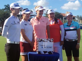 LPGA golfers, from left, Sung Hyun Park, So Yeon Ryu, Lexi Thompson, Shanshan Feng and Brooke Henderson pose before a glass case, Tuesday, Nov. 14, 2017,  reflecting the $1 million cash bonus up for grabs this week at the CME Group Tour Championship golf tournament at Tiburon Golf Club in Naples, Fla. (AP Photo/Doug Ferguson)