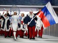 Alexander Zubkov carries the Russian flag as he leads his team during the opening ceremony of the 2014 Winter Olympics in Sochi, Russia, on Feb. 7, 2014. Nineteen Russian athletes have been disciplined for doping at the Sochi games, including Zubkov.