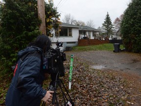 A journalist films a house in Sainte-Marthe-Sur-Le-Lac, Que., Thursday, Nov.2, 2017. Quebec provincial police say a woman is facing three counts of first-degree murder in the deaths of three newborns. THE CANADIAN PRESS/Ryan Remiorz