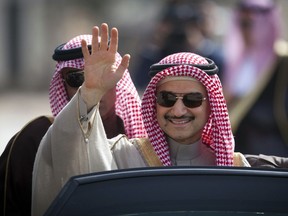 FILE - In this Feb. 4, 2014 file photo, Saudi billionaire Prince Alwaleed bin Talal, waves as he arrives at the headquarters of Palestinian President Mahmoud Abbas in the West Bank city of Ramallah.  Saudi Arabia has arrested dozens of princes and former government ministers, including a well-known billionaire with extensive holdings in Western companies, as part of a sweeping anti-corruption probe, further cementing King Salman and his crown prince son's control of the kingdom. A high-level employee at Prince Alwaleed bin Talal's Kingdom Holding Company told The Associated Press that the royal was among those detained overnight Saturday, Nov. 4, 2017. (AP Photo/Majdi Mohammed, File)