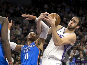 Oklahoma City Thunder guard Russell Westbrook, left, and Sacramento Kings center Kosta Koufos vie for the ball during the first quarter of an NBA basketball game Tuesday, Nov. 7, 2017, in Sacramento, Calif. (AP Photo/Rich Pedroncelli)