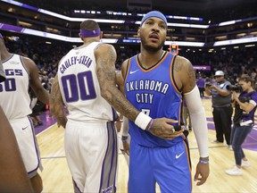 Sacramento Kings center Willie Cauley-Stein, left, and Oklahoma City Thunder forward Carmelo Anthony pass each other after the Kings defeated the Thunder 94-86 in an NBA basketball game Tuesday, Nov. 7, 2017, in Sacramento, Calif. (AP Photo/Rich Pedroncelli)