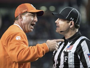 Clemson head coach Dabo Swinney, left, communicates with an official during the first half of an NCAA college football game against South Carolina, Saturday, Nov. 25, 2017, in Columbia, S.C. (AP Photo/Sean Rayford)