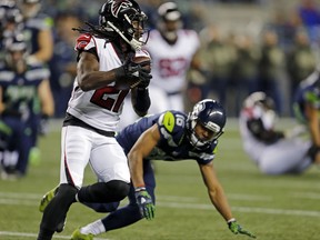 Atlanta Falcons' Desmond Trufant (21) runs with the ball after intercepting it as Seattle Seahawks' Tyler Lockett tumbles behind in the first half of an NFL football game, Monday, Nov. 20, 2017, in Seattle. (AP Photo/Stephen Brashear)
