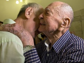 In this Thursday, Nov. 16, 2017 photo, Israeli Holocaust survivor Eliahu Pietruszka, right, embraces Alexandre Pietruszka as they meet for the first time in Kfar Saba. Pietruszka who fled Poland at the beginning of the Second World War and thought his entire family had perished learned that a younger brother had also survived, and his son, 66-year-old Alexandre, flew from Russia to see him. (AP Photo/Sebastian Scheiner)
