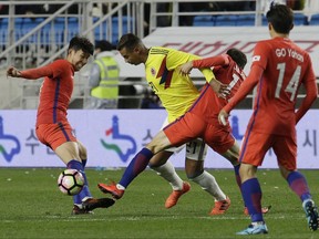 Colombia's Edwin Cardona, second from left, fights for the ball against South Korea' Lee Jae-sung and Son Heung-min, left, during their friendly soccer match at Suwon World Cup Stadium in Suwon, South Korea, Friday, Nov. 10, 2017. (AP Photo/Ahn Young-joon)