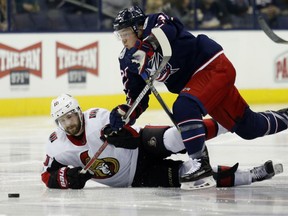 Blue Jackets forward Cam Atkinson, top, chases the puck against the Ottawa Senators' Tom Pyatt during the second period of their game in Columbus, Ohio, on Friday night.