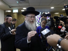 Israeli Health Minister Yaakov Litzman, who is also chairman of the ultra-Orthodox United Torah Judaism party, speaks to journalists after handing in his resignation to Israel's Prime Minister Benjamin Netanyahu on Sunday.