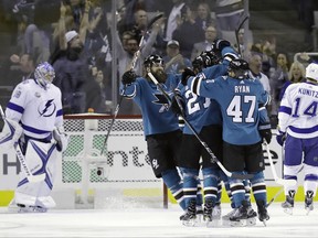 San Jose Sharks' Joonas Donskoi, center, is hugged by teammates after scoring against the Tampa Bay Lightning during the first period of an NHL hockey game Wednesday, Nov. 8, 2017, in San Jose, Calif. (AP Photo/Marcio Jose Sanchez)