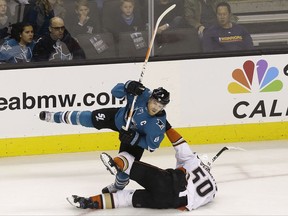 San Jose Sharks center Joe Pavelski, top, is pulled down by Anaheim Ducks center Antoine Vermette (50) during the first period of an NHL hockey game in San Jose, Calif., Saturday, Nov. 4, 2017. (AP Photo/Jeff Chiu)