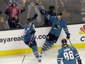 San Jose Sharks right wing Joonas Donskoi, from Finland, upper right, is congratulated by center Tomas Hertl (48), from the Czech Republic, and defenseman Brent Burns (88) after scoring a goal against the Anaheim Ducks during the first period of an NHL hockey game in San Jose, Calif., Monday, Nov. 20, 2017. (AP Photo/Jeff Chiu)