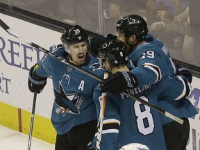 San Jose Sharks center Logan Couture, left, is congratulated by center Joe Pavelski (8) and center Joe Thornton (19) after scoring a goal against the Winnipeg Jets during the first period of an NHL hockey game in San Jose, Calif., Saturday, Nov. 25, 2017. (AP Photo/Jeff Chiu)