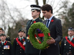 Prime Minister Justin Trudeau places a wreath during an event to mark the upcoming Veterans' Week and 100th anniversary of the Battle of Passchendaele at the National Military Cemetery in Ottawa on Friday, Nov. 3, 2017.