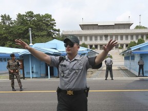 In this July 19, 2017, file photo, a South Korea army soldier gestures at the border villages of Panmunjom in Paju, South Korea.