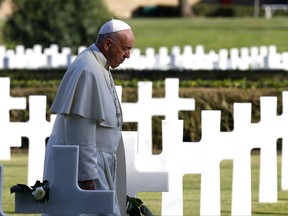 Pope Francis walks past marble crosses at the American military cemetery in Nettuno, Italy, Thursday, Nov. 2, 2017. Pope Francis is underlining the price of war, visiting an American military cemetery and the site of a Nazi massacre in Rome. The pope will first say Mass in the Sicily-Rome American Cemetery, where 7,680 American war dead who helped liberate southern and central Italy during World War II are buried and 3,095 missing are commemorated. From there, the pope travels to the Ardeatine Caves, the site of one of the worst massacres of Nazi-occupied Rome. (Stefano Rellandini/Pool Photo via AP)