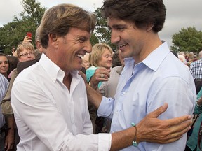 Justin Trudeau, right, chats with Stephen Bronfman, the party's chief fundraiser, at a barn party in St. Peters Bay, P.E.I. on Wednesday, Aug. 28, 2013.