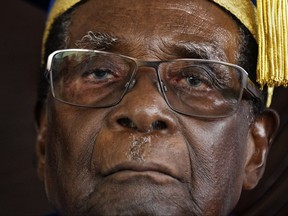 FILE - In this Friday Nov. 17, 2017 file photo, Zimbabwean President Robert Mugabe attends a graduation ceremony on the outskirts of Harare. Zimbabwe's Parliament erupted in cheers Tuesday Nov. 21, 2017 after the speaker announced the resignation of President Robert Mugabe after 37 years in power. (AP Photo/Ben Curtis, File)