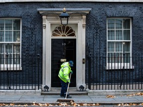 A street cleaner sweeps leaves outside Number 10 Downing Street on November 13, 2017 in London, England.