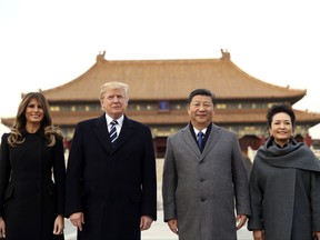 FILE - In this Nov. 8, 2017, file photo, U.S. President Donald Trump, second left, first lady Melania Trump, left, Chinese President Xi Jinping and his wife Peng Liyuan stand together as they tour the Forbidden City in Beijing, China. As President Donald Trump steers his administration's focus inward, China has stepped into what many see as a U.S.-sized void left behind in Southeast Asia. (AP Photo/Andrew Harnik, File)