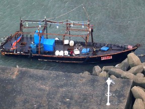 A wooden boat is moored at a nearby marina, in Yurihonjo, Akita prefecture, northern Japan, Friday, Nov. 24, 2017. Japanese police are investigating eight men found on Japan's northern coast who say they are from North Korea and washed ashore after their boat broke down.