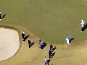 In this aerial image, U.S. President Donald Trump, second from right,  Japanese Prime Minister Shinzo Abe, left, and Japanese golfer Hideki Matsuyama, third from right in blue,  play golf at the Kasumigaseki Country Club in Kawagoe, north of Tokyo, Sunday, Nov. 5, 2017.  President Trump and Prime Minister Abe are calling their golf outing a success. The two leaders played Sunday with Japanese professional Matsuyama at a championship golf course outside of Tokyo.  (Kyodo News via AP)