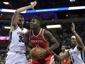 Houston Rockets center Clint Capela (15) drives between Memphis Grizzlies center Marc Gasol (33) and guard Mario Chalmers (6) during the first half of an NBA basketball game Saturday, Nov. 18, 2017, in Memphis, Tenn. (AP Photo/Brandon Dill)