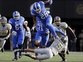 Kentucky running back Benny Snell Jr. (26) leaps over Vanderbilt safety LaDarius Wiley (5) in the first half of an NCAA college football game Saturday, Nov. 11, 2017, in Nashville, Tenn. (AP Photo/Mark Humphrey)