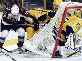 Colorado Avalanche left wing Matt Nieto (83) and Nashville Predators center Kyle Turris, center, fight for the puck behind goalie Pekka Rinne (35), of Finland, during the first period of an NHL hockey game, Saturday, Nov. 18, 2017, in Nashville, Tenn. (AP Photo/Mark Zaleski)