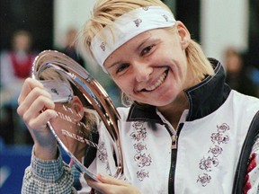 FILE - In this Nov. 17, 1996 file photo, Jana Novotna, of the Czech Republic, is all smiles after taking home a $79,000 check from the Advanta Tennis Championship in Villanova, Pa. The WTA says the 1998 Wimbledon champion Jana Novotna of the Czech Republic has died. In a Monday, Nov. 20, 2017 statement, the WTA say Novotna died after battling a cancer on Sunday, Nov. 19. She was 49.(AP Photo/Jim Graham, File)
