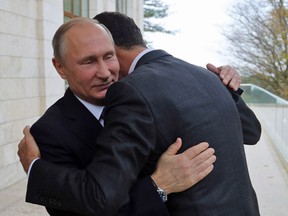 Russia's President Vladimir Putin (L) embraces his Syrian counterpart Bashar al-Assad during a meeting in Sochi on November 20, 2017.