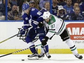Tampa Bay Lightning center Steven Stamkos, left, battles with Dallas Stars center Tyler Seguin, right, for the puck during the third period of an NHL hockey game Thursday, Nov. 16, 2017, in Tampa, Fla. (AP Photo/Chris O'Meara)