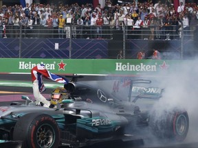 In this Oct. 29, 2017 photo, Mercedes driver Lewis Hamilton, of Britain, celebrates at the end of the Formula One Mexico Grand Prix auto race at the Hermanos Rodriguez racetrack in Mexico City. Hamilton won his fourth career Formula One season championship on Sunday with a ninth-place finish at the Mexican Grand Prix in a race won by Red Bull's Max Verstappen.(AP Photo/Rebecca Blackwell)