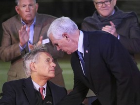 U.S. Vice President Mike Pence, right, shakes hands with Texas Governor Greg Abbott at a prayer vigil for the victims of the shooting at Sutherland Springs First Baptist Church, held at the Floresville High School Football Stadium, Wednesday, Nov. 8, 2017, in Floresville, Texas. (Louis DeLuca/The Dallas Morning News via AP)