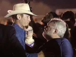Stephen Willeford, right, hugs Johnnie Langendorff during a vigil for the victims of the First Baptist Church shooting Monday, Nov. 6, 2017, in Sutherland Springs, Texas. Willeford shot suspect Devin Patrick Kelley and Langendorff drove the truck while they chased Kelley. Kelley opened fire inside the church in the small South Texas community on Sunday, killing more than two dozen and injuring others. (AP Photo/David J. Phillip)