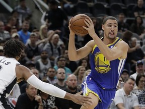 Golden State Warriors guard Klay Thompson (11) drives to the base past San Antonio Spurs guard Patty Mills during the first half of an NBA basketball game, Thursday, Nov. 2, 2017, in San Antonio. (AP Photo/Eric Gay)